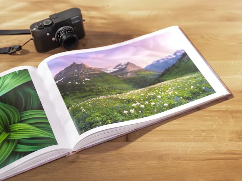Livro fotográfico aberto com fotografias de paisagem