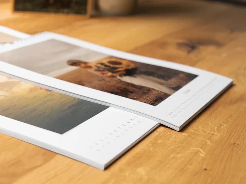 Calendários fotográficos impressos sobre uma mesa de madeira